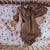 A baby girl asleep in a cot with our york fitted sheet and a brown blanket over her. 