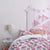 A pink room with a bed in the middle with our Hastings pattern on it. 