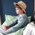A picture of a young boy wearing a hat sitting on a bed with our Banbury duvet cover. 