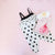 A Duchess fitted sheet with a black and white onsie, a book and a flower crown sitting on top. 