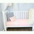 A cot with a Duchess sheet set on it which includes a fitted and flat sheet.